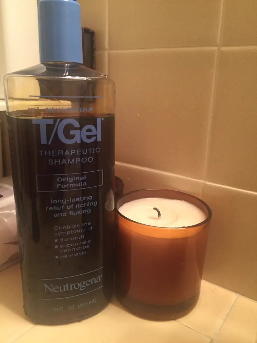 T/Gel bottle beside a candle in an at-home setting