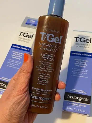 T/Gel bottle held in front of two cartons