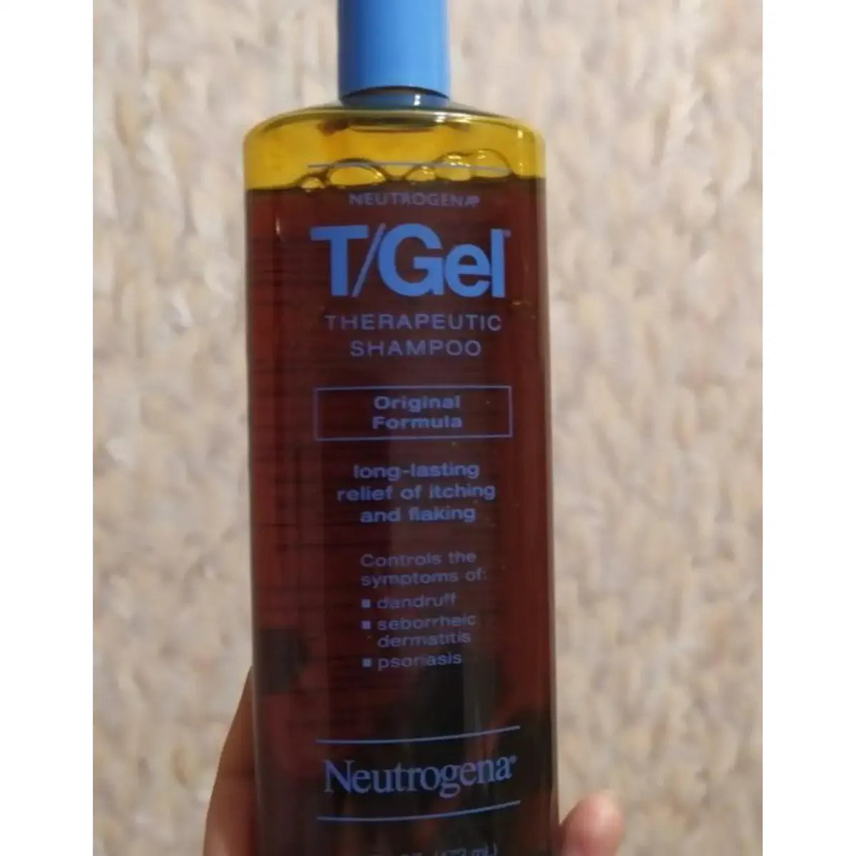 T/Gel bottle close-up against a neutral wall