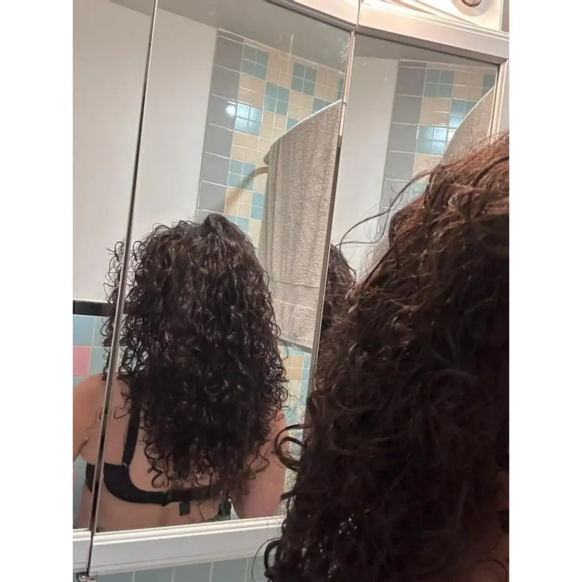 Customer with long wet curly hair in a bathroom