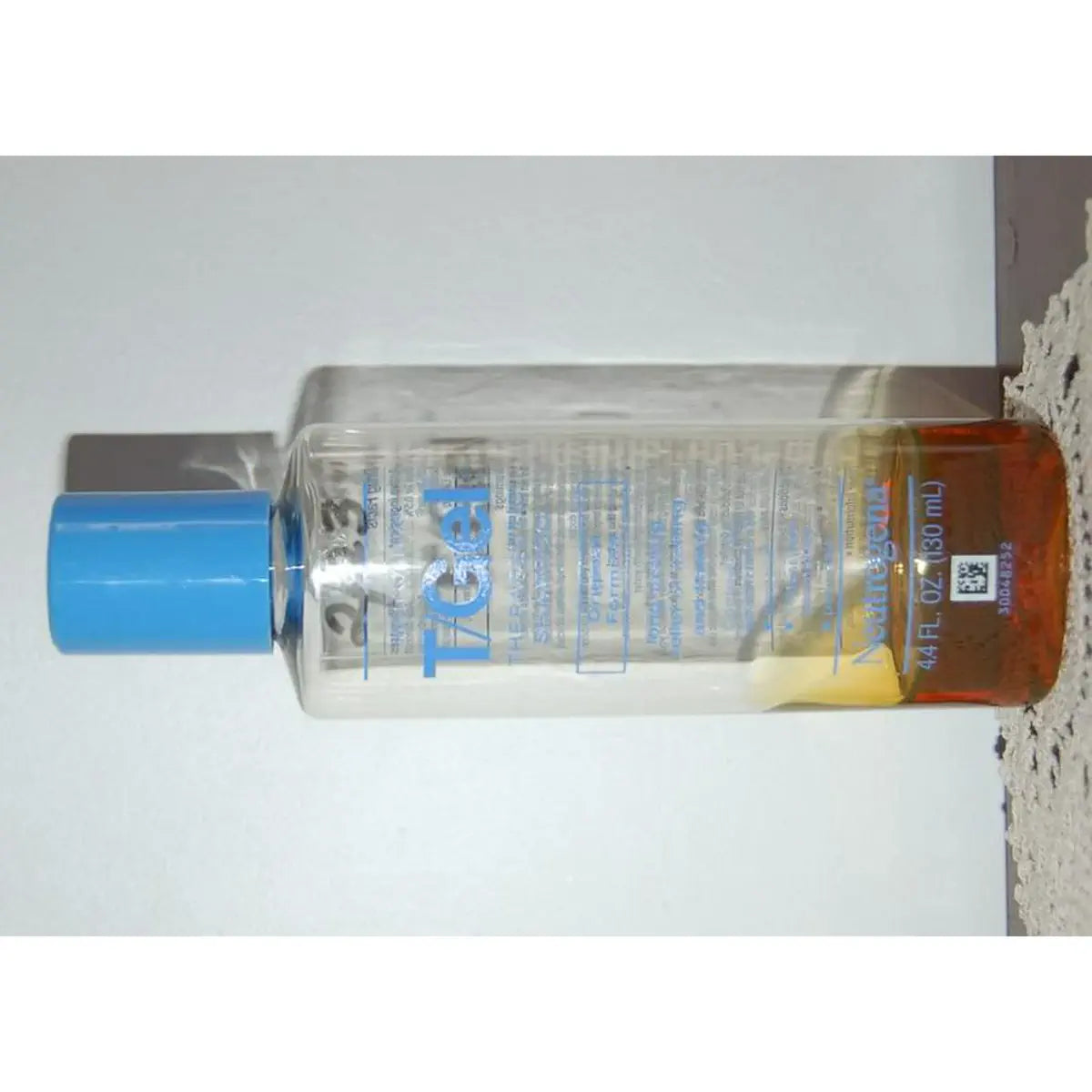 Near-empty T/Gel bottle with amber shampoo residue